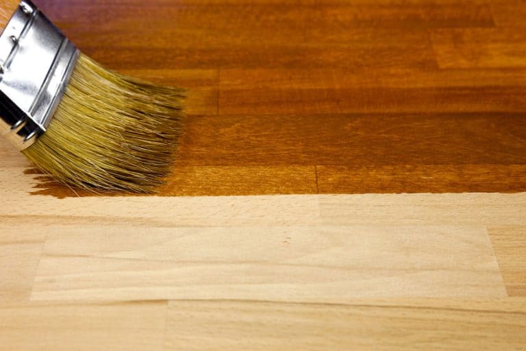 Applying polyurethane on a piece of wood to stain it