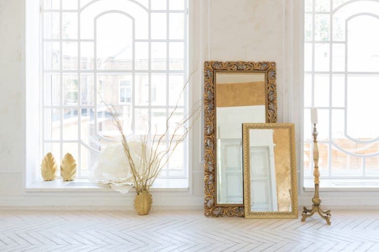 A white empty room with a classy mirror placed next to a wall, How To Put Mirrors On Walls Without Nails