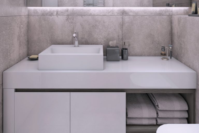 当代室内用混凝土小浴室textured wall with toilet seat, sink and mirror, how to paint a bathroom sink