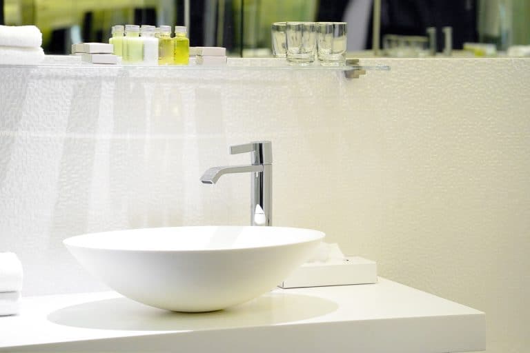 A modern white bathroom sink with a luxurious faucet and a white granite countertop, Should Bathroom Sink Match the Toilet?