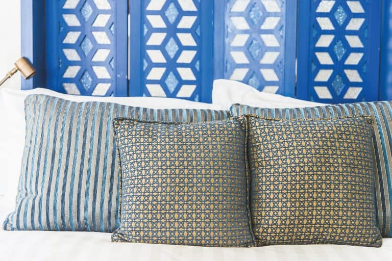 Assorted pillow shams on white linen bed, Should Pillow Shams Match Comforter?