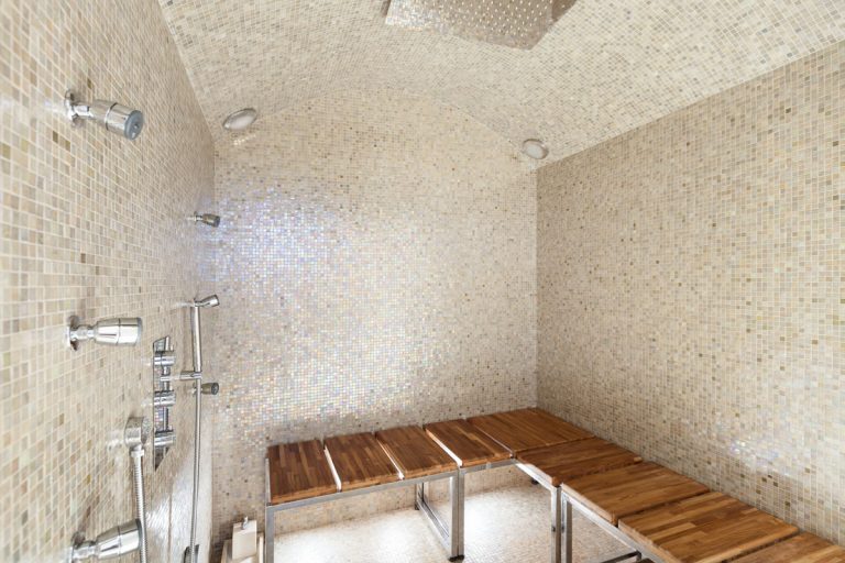 Decorative tiled bathroom with a wooden bench and metal frames, How Much Weight Can A Shower Bench Hold?