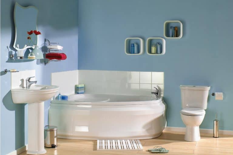 Blue bathroom with bath, sink, toilet and toiletries, and bathroom rug, How To Wash Bathroom Rugs [Machine and Hand Washing Explored]
