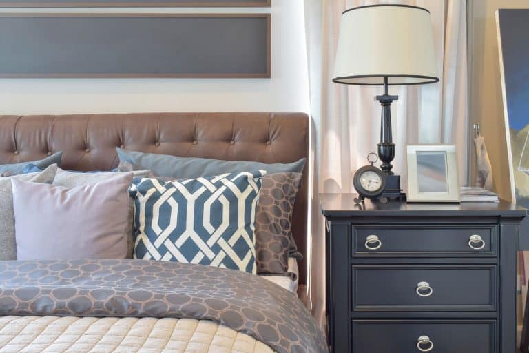 A comfortable bedroom with comfy beddings, lots of pillows, and a nightstand with a lampshade on top, What Size Lamp For Nightstand?