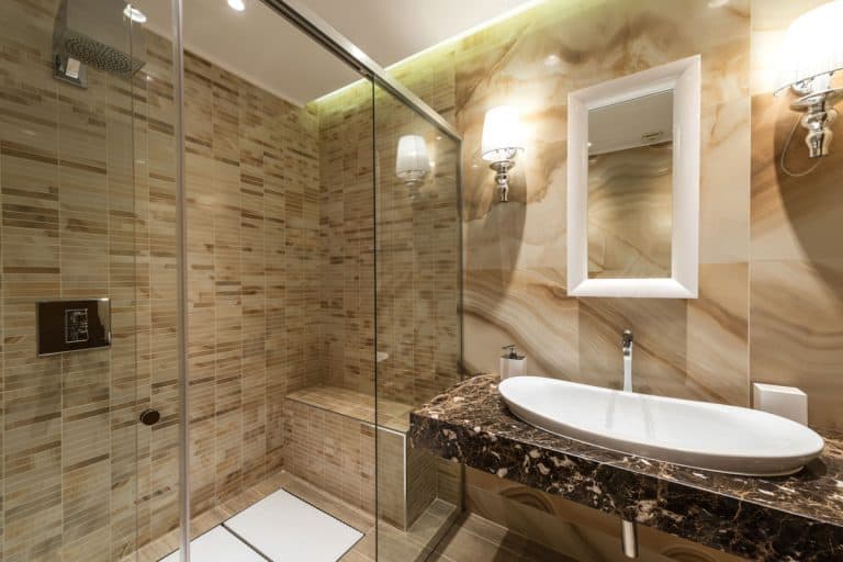 A gorgeous contemporary bathroom with brown textured tiles, modern vanity, and a small shower bench in the shower area, Where To Put A Shower Bench