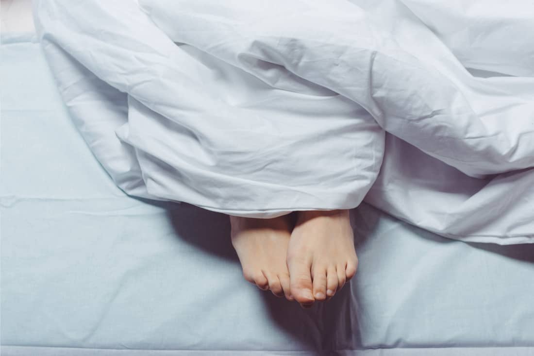 女性的脚在法兰绒毯子下面，床上有法兰绒床单，法兰绒床单的利弊