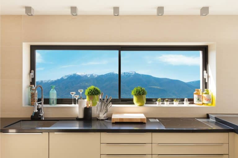 Kitchen window facing a beautiful scenery, potted plants and small containers on window sill, 15 Eye-Catching Kitchen Window Treatment Ideas