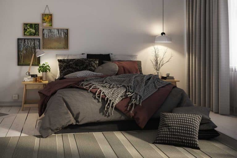 A warm and cozy Scandinavian style bedroom interior with fireplace and framed artwork on wall, 21 Bedroom Must-Haves [The Complete Guide!]