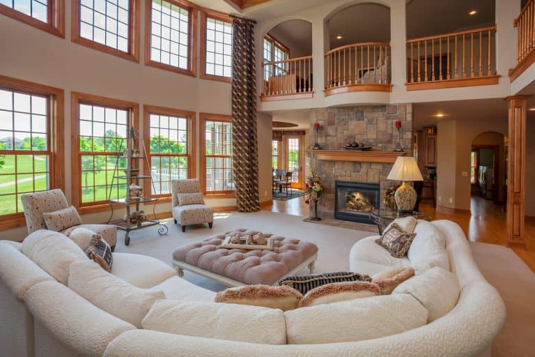 Interior of an amazing two storey living room with a rustic approach to the design and long white curved sofa, 12 Large Living Room Floor Plans You Need To See