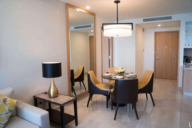 A contemporary themed living room apartment with luxurious dining set, square armed sofa, and a huge ceiling lamp at the dining area, How High Should You Hang A Full-Length Mirror?