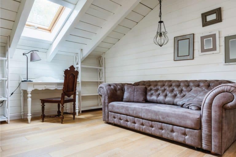 sofa in a cozy room with frames hanging on a wall. 5 Ways To Keep Pictures From Falling Off The Wall