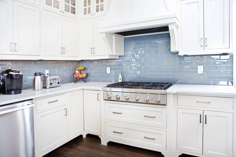 当代家庭厨房用不锈钢ppliances and painted white cabinets, Should The Backsplash Match The Countertop Or Floor?