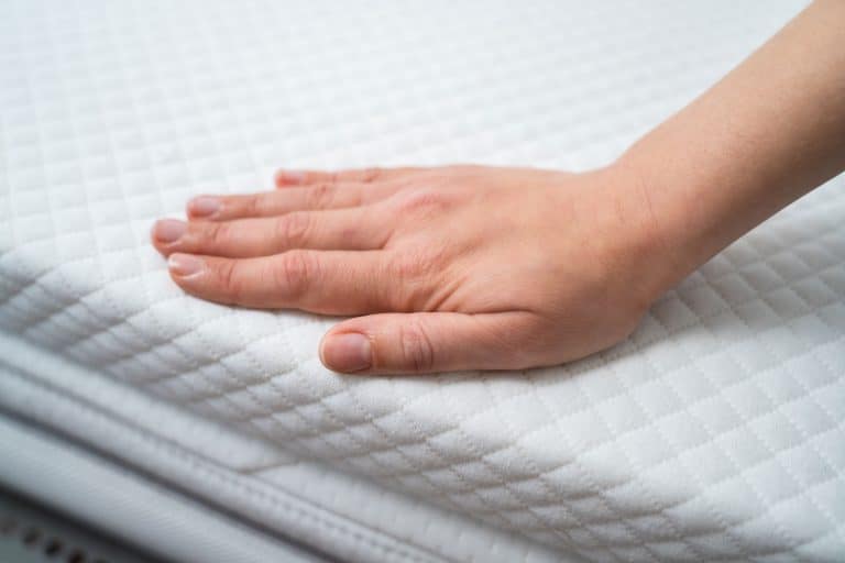 一个女人把床垫套放在泡沫床垫上，你能把床垫套放在泡沫床垫上吗?