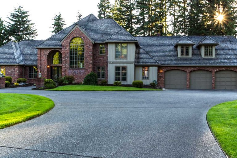 Large concrete driveway to a home, Should The Driveway Be Higher Than The Lawn? [And What Type Of Border To Use!]