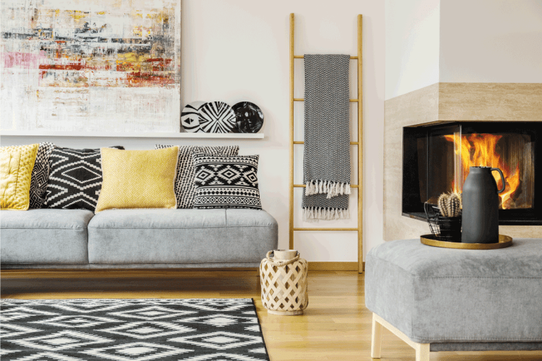 Pillows on grey settee in warm living room interior with painting and fireplace. 10 Amazing 12 X 14 Living Room Layout Ideas