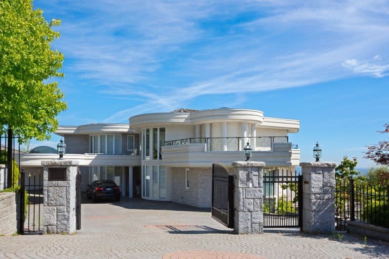 The front of a large luxury home in an expensive subdivision, Should A Driveway Gate Open In Or Out?