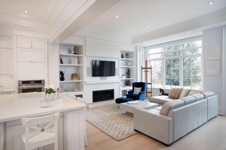 White modern interior living room with a white sectional sofa, white dividers, and a wall mounted TV, 9 Captivating Layouts For A Living Room With A Large Window