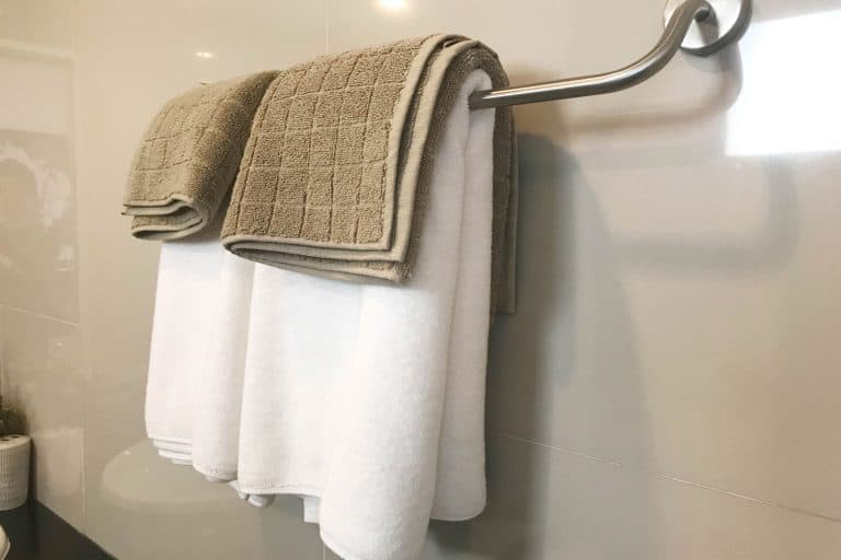 Towels hanged inside the bathroom, Should You Hang Towels Over The Toilet? [And How High Above?]