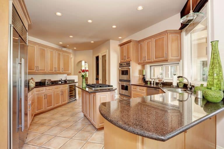 Oak cabinetries incorporated with brown marble countertops and recessed lighting, What Color Cabinets Go With Brown Countertops?