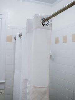 白色的浴室淋浴带老式瓷砖在旧小屋中 - 如何用漂白剂洗浴帘