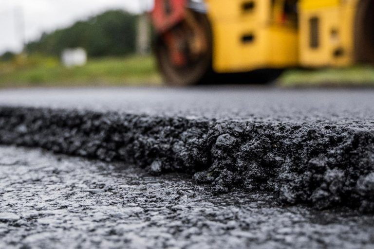 一个heavy vibration roller compactor press new hot asphalt on the roadway, Can You Lay Concrete Or Cement Over Bitumen?