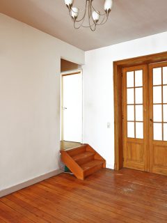 室内老化的木门在空房间内带着眼镜框架，手风琴门是否挡住声音？