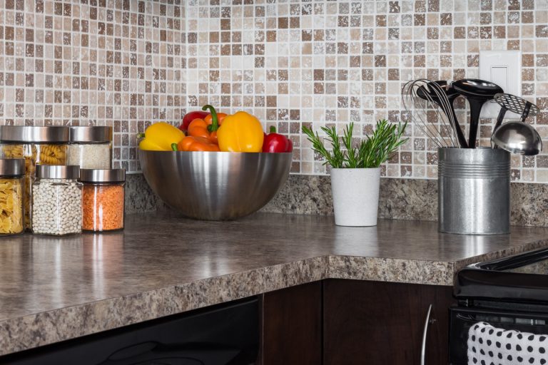 Food ingredients and herbs on granite kitchen countertop, How Much Does Granite Weigh? [Countertops Explored]