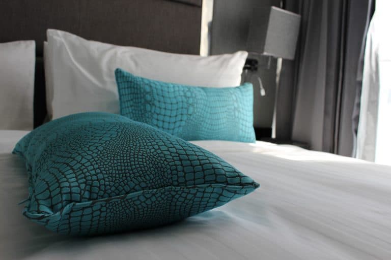 Turquoise color pillows inside a dark gray themed bedroom, 15 Wall Decor Ideas For A Masculine Bedroom Or Den
