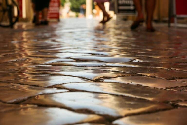 Paving stones made of limestone, smoothly polished over centuries, on a road from Roman times in the Mediterranean region (focus detail). - Do You Need To Seal Limestone Paving?