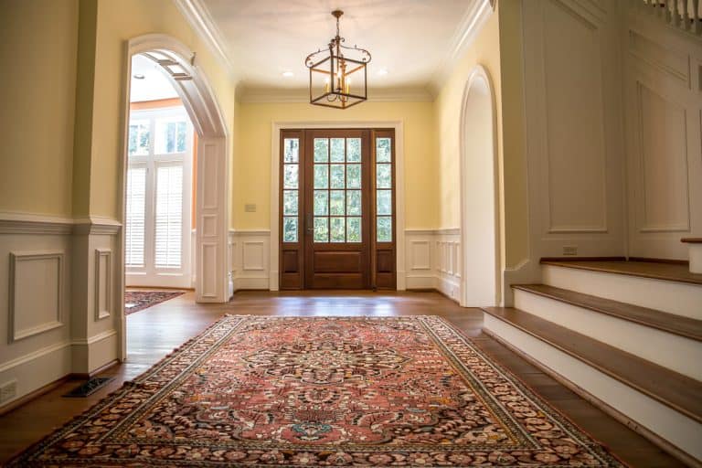 Classic American themed living room with beige walls, white trims and wooden flooring with a huge wooden front door, Are Ruggables Good for High-Traffic Areas?