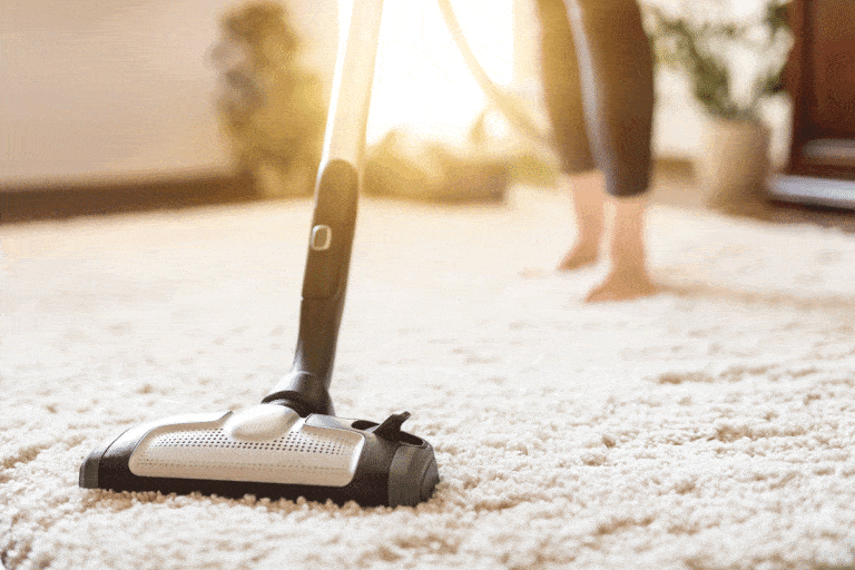 Young-woman-using-a-vacuum-cleaner-while cleaning carpet in the house, Can You Use A Ryobi Vacuum Without A Bag?