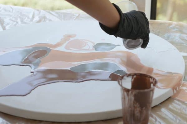 Applying epoxy resin onto piece of wood